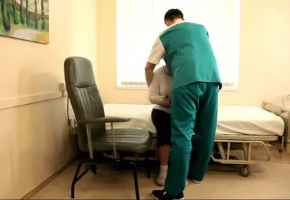 Уход за больным. Как правильно пересадить больного в кресло при помощи ассистента.