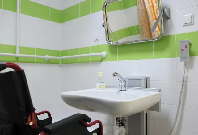 Доступный санузел клиники с регулируемым оборудованием и поручнями